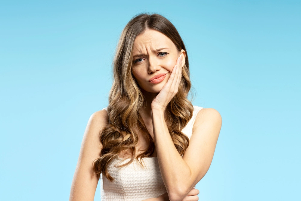 Woman experiencing tooth pain and holding her cheek